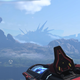 Master Chief stares at a guardian on a cliff in Halo Infinite.